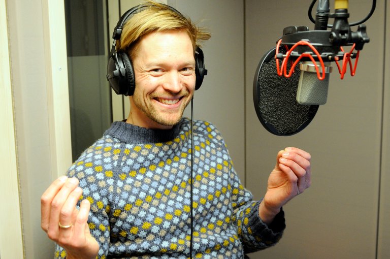 Håkon Sigernes smiler og gestikulerer i lydstudioet