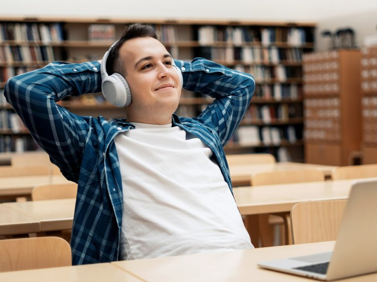 Mannlig student med øretelefoner og PC