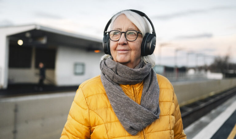 Smilende eldre låner med hodetelefoner