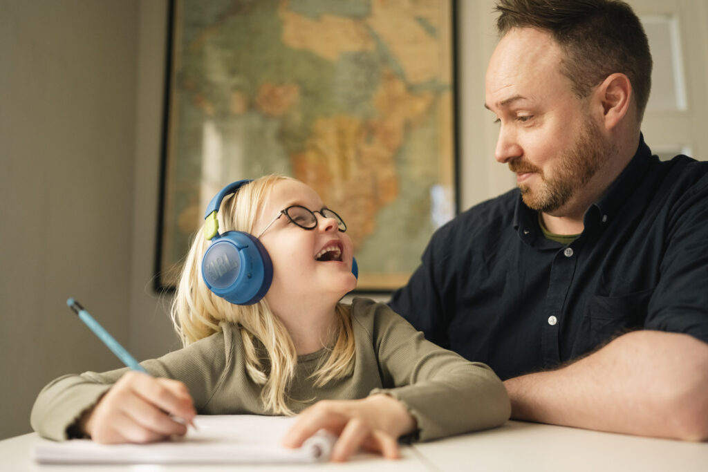 Jente gjør skolearbeid sammen med far