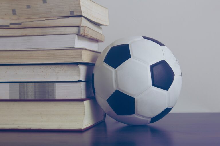 En fotball ved siden av stabel med bøker.