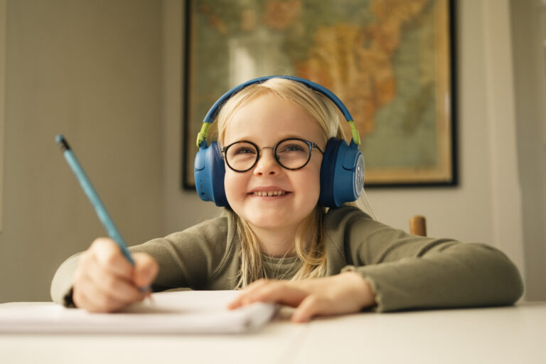 Smilende skolejente med briller og hodetelefoner